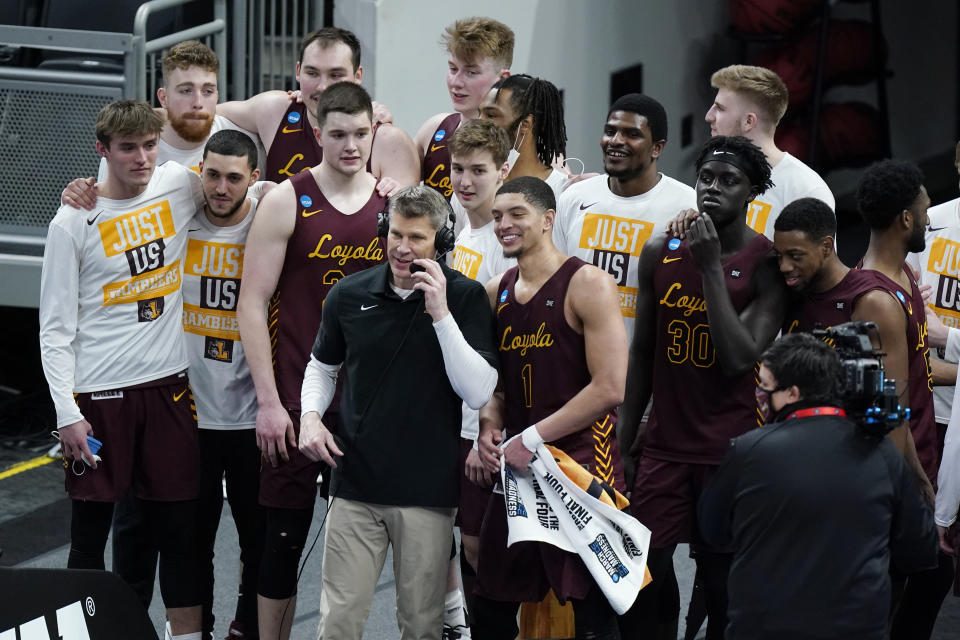 Loyola of Chicago players celebrate with head coach Porter Moser after beating Illinois in a college basketball game in the second round of the NCAA tournament at Bankers Life Fieldhouse in Indianapolis Sunday, March 21, 2021. Loyola upset Illinois 71-58. (AP Photo/Mark Humphrey)