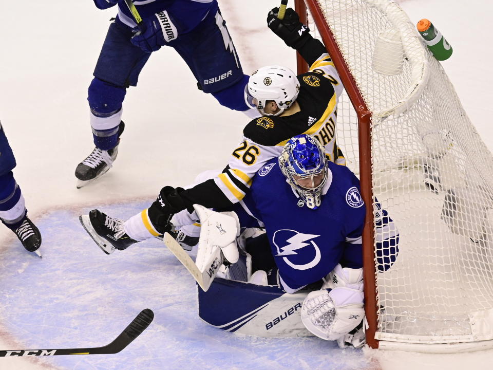Boston Bruins center Par Lindholm (26) collides with Tampa Bay Lightning goaltender Andrei Vasilevskiy (88) during the second overtime period of NHL Stanley Cup Eastern Conference playoff hockey game action in Toronto, Monday, Aug. 31, 2020. (Frank Gunn/The Canadian Press via AP)