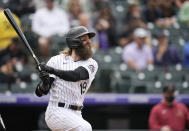 Colorado Rockies Charlie Blackmon follows the flight of his two-run home run off Arizona Diamondbacks starting pitcher Madison Bumgarner in the sixth inning of a baseball game Saturday, May 22, 2021, in Denver. (AP Photo/David Zalubowski)