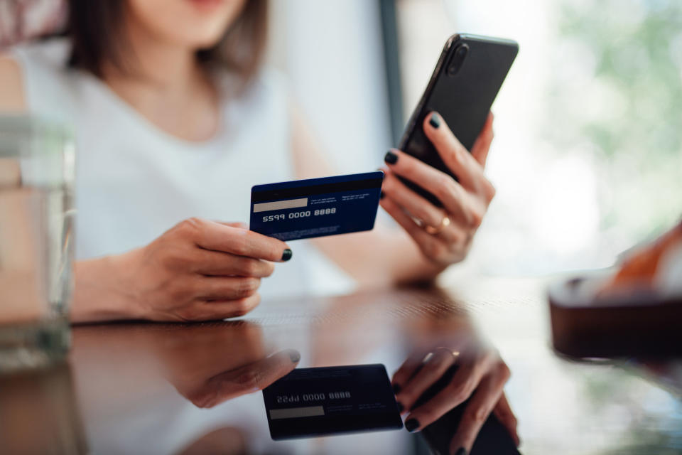 a person looking at her credit card and phone