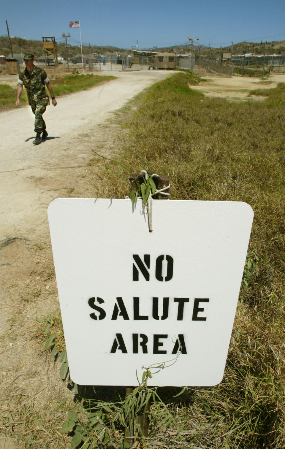 A soldier walks past a "No Salute Area" sign, posted to keep the ranks of military officers secret from detainees, at Camp X-Ray April 24, 2002 in Guantanamo Bay, Cuba. Some 300 alleged Taliban and al Qaeda detainees have been brought to Camp X-Ray from Kandahar, Afghanistan. The detainees will soon be moved to Camp Delta which is expected to be finished within days. (Photo by Mario Tama/Getty Images)
