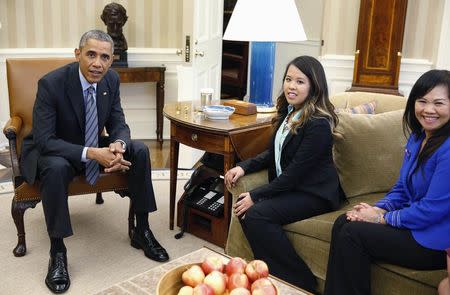 U.S. President Barack Obama talks with Dallas nurse Nina Pham (C) as her mother Diane listens at the Oval Office in Washington, October 24, 2014. REUTERS/Larry Downing