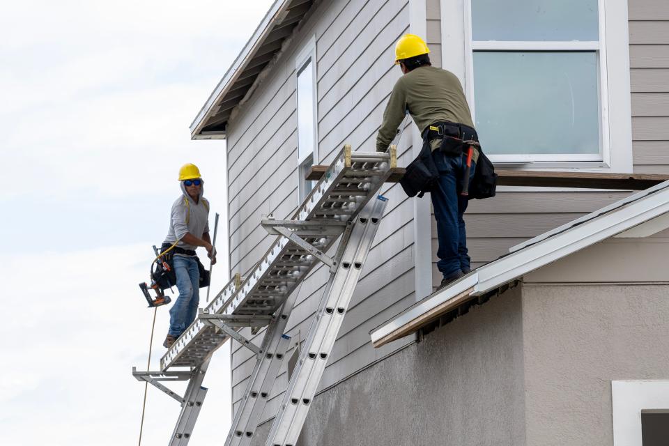 Men work on building a new house at the Liberty Preserve subdivision in Leesburg.