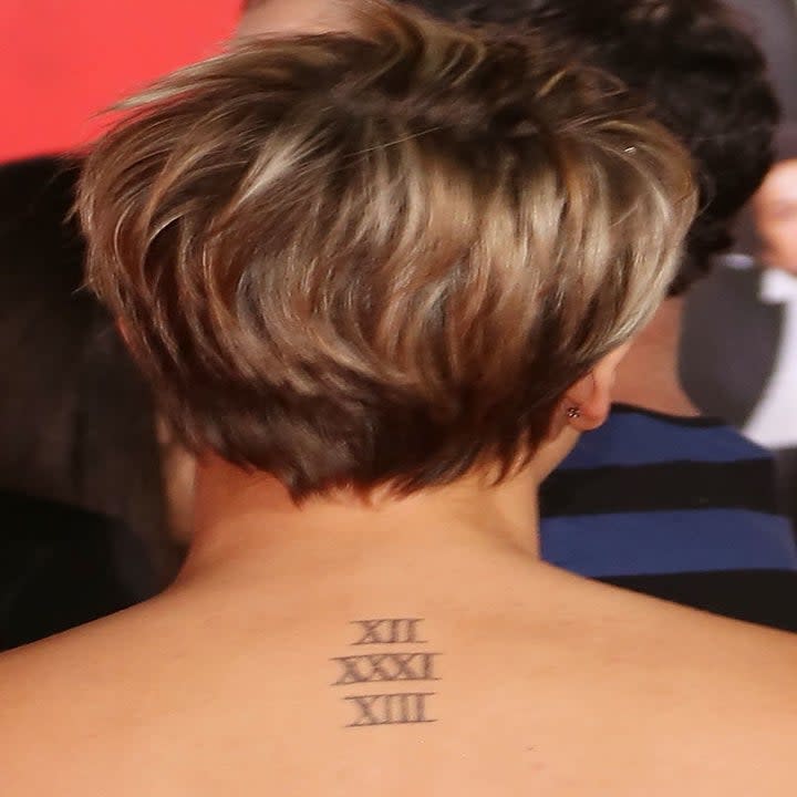 The date (12/31/13) in roman numerals on the back of her neck
