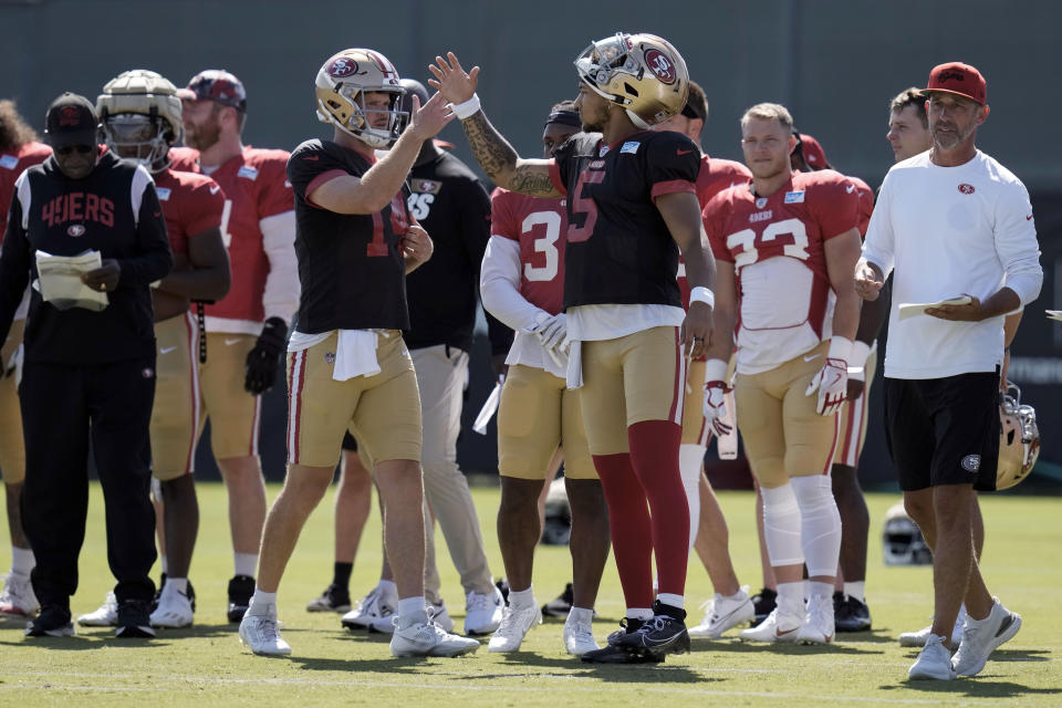 San Francisco 49ers quarterback Sam Darnold, center left, and Trey Lance (5) high-five during NFL football training camp Friday, Aug. 4, 2023, in Santa Clara, Calif. (AP Photo/Godofredo A. Vásquez)