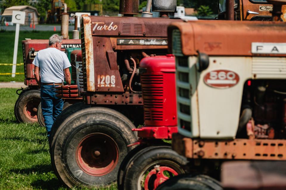 A man walks past antique tractors during the annual Tuscarawas Valley Pioneer Power show, Friday Aug. 18 at the Tuscarawas County Fairgrounds in Dover. The event, which happens yearly, is also known as the Dover Steam Show.