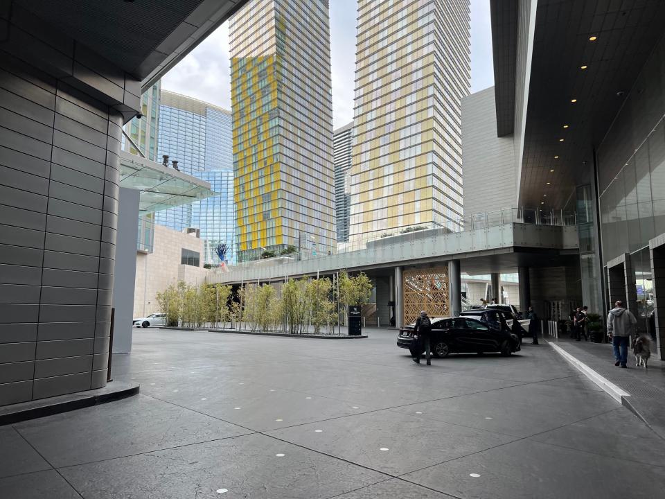 A turncourt parking entrance next to big buildings.