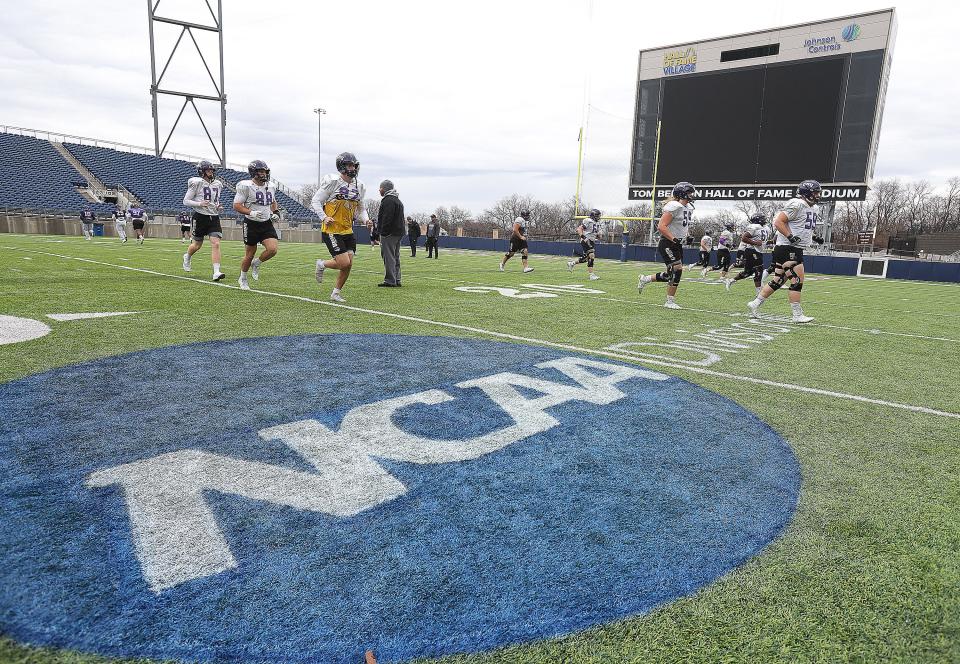 University of Mary Hardin-Baylor players warm up Wednesday during a practice at Tom Benson Hall of Fame Stadium in Canton. Mary Hardin-Baylor and North Central College are playing Friday in the Stagg Bowl.