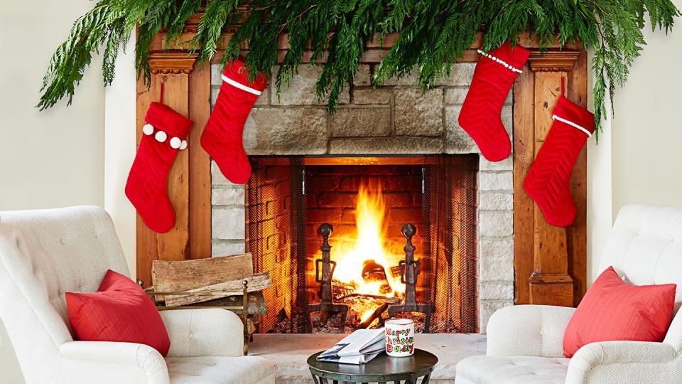 holiday decorating idea fireplace and mantel with pine boughs and garlands and christmas stockings