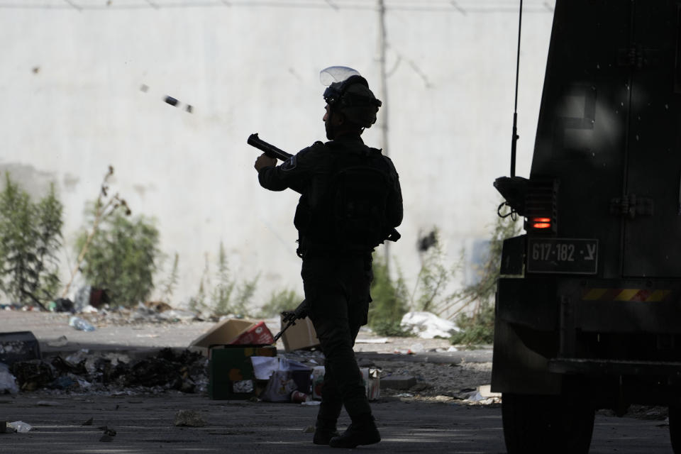 Israeli border policeman fires teargas during a raid on Balata, a Palestinian refugee camp in Nablus, West Bank, Thursday, Nov. 23, 2023. (AP Photo/Majdi Mohammed)