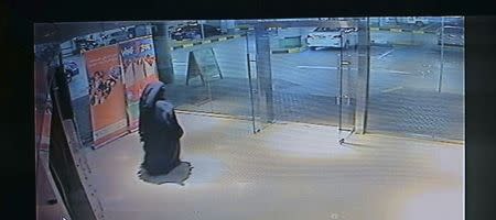 A person, dressed in a black robe and suspected in the killing of a U.S. woman at a shopping mall at Al Reem Island in Abu Dhabi is seen in this still image taken from a monitoring camera footage provided by Abu Dhabi Police on December 3, 2014. REUTERS/Abu Dhabi Police/Handout via Reuter