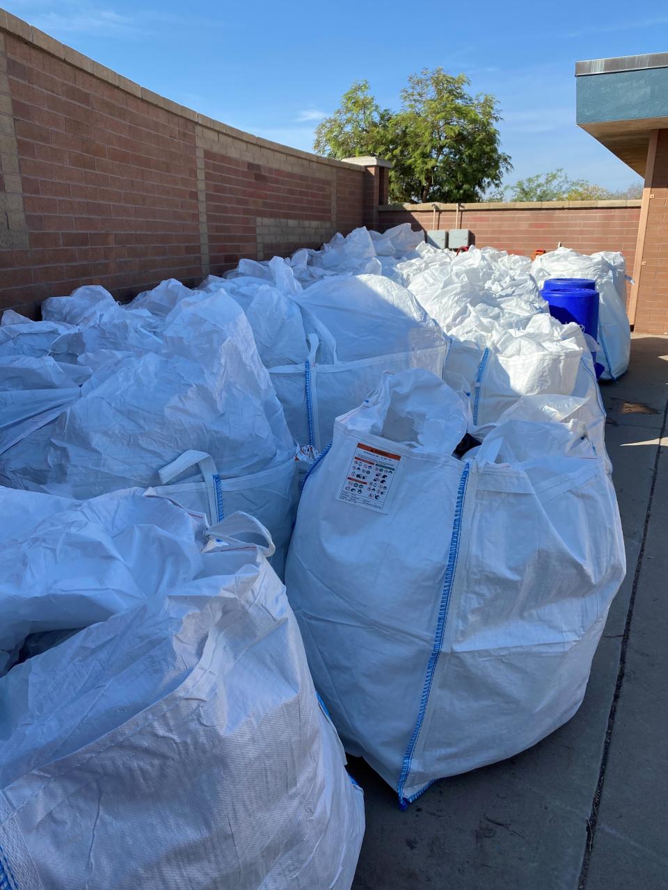 Sailcloth bags with two-weeks worth of recycled waste collected by volunteers sit at the back of Mesquite Elementary School, in Casa Grande, AZ.