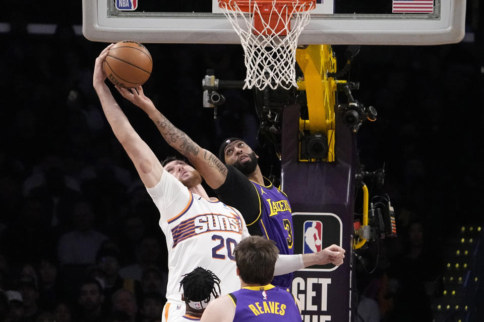 Phoenix Suns center Jusuf Nurkic, left, and Los Angeles Lakers forward Anthony Davis reach for a rebound during the first half of an NBA basketball game Thursday, Jan. 11, 2024, in Los Angeles. (AP Photo/Mark J. Terrill)