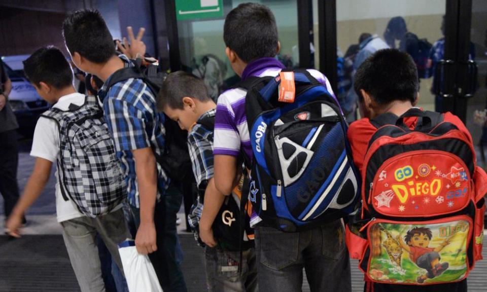 Guatemalan children caught in Mexico while trying to migrate into the US, queue before climbing into a minibus at Aurora international airport in Guatemala City.