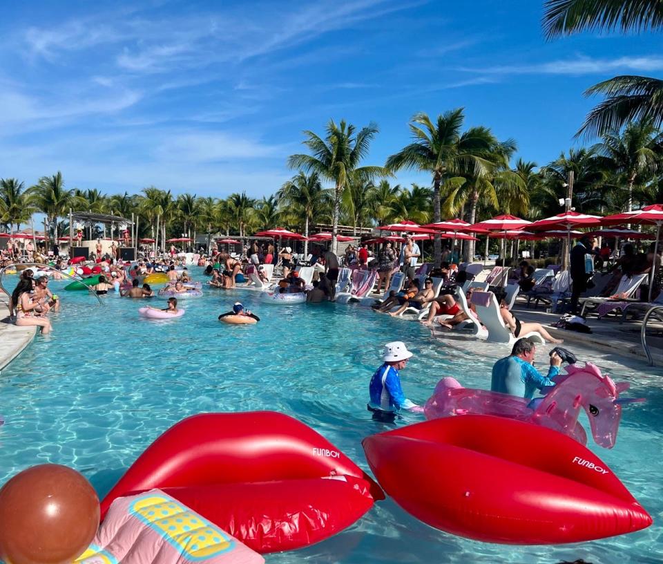 Float On party at Beach Club at Bimini, people in a pool with floats and sitting nearby under umbrellas