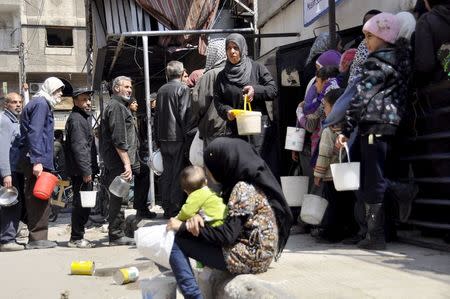 Residents wait in line to receive food aid in Yarmouk camp April 14, 2015. REUTERS/Moayad Zaghmout