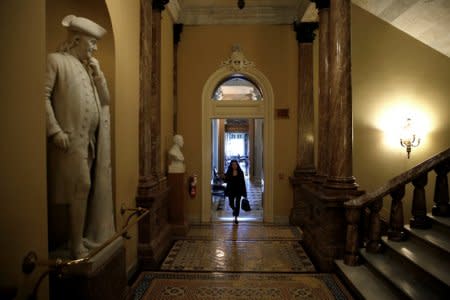 A woman walks past a statue of Benjamin Franklin after President Donald Trump and the U.S. Congress failed to reach a deal on funding for federal agencies on Capitol Hill in Washington, U.S., January 20, 2018.      REUTERS/Joshua Roberts