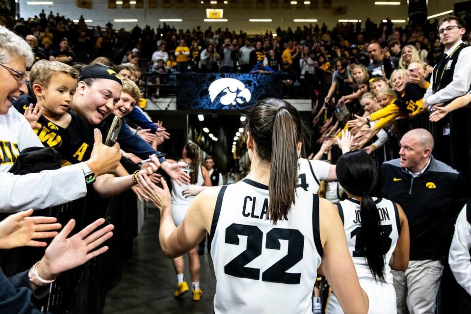 Iowa guard Caitlin Clark (22) high-fives fans after a late October exhibition game at Carver-Hawkeye Arena in Iowa City, Iowa. JOSEPH CRESS/FOR THE REGISTER/JOSEPH CRESS/FOR THE REGISTER / USA TODAY NETWORK