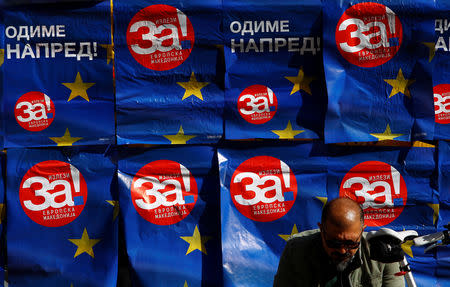 A man sits next to posters reading "yes" for the referendum in Macedonia on changing the country's name that would open the way for it to join NATO and the European Union, in Skopje, Macedonia September 26 2018. REUTETS/Ognen Teofilovski