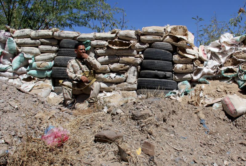 Activist turned fighter Ahmed Abdo Hezam, known as Ahmed Abu Al-Nasr is pictured with his comrades as they take position at a frontline post in the fight against Houthi fighters in Taiz, Yemen