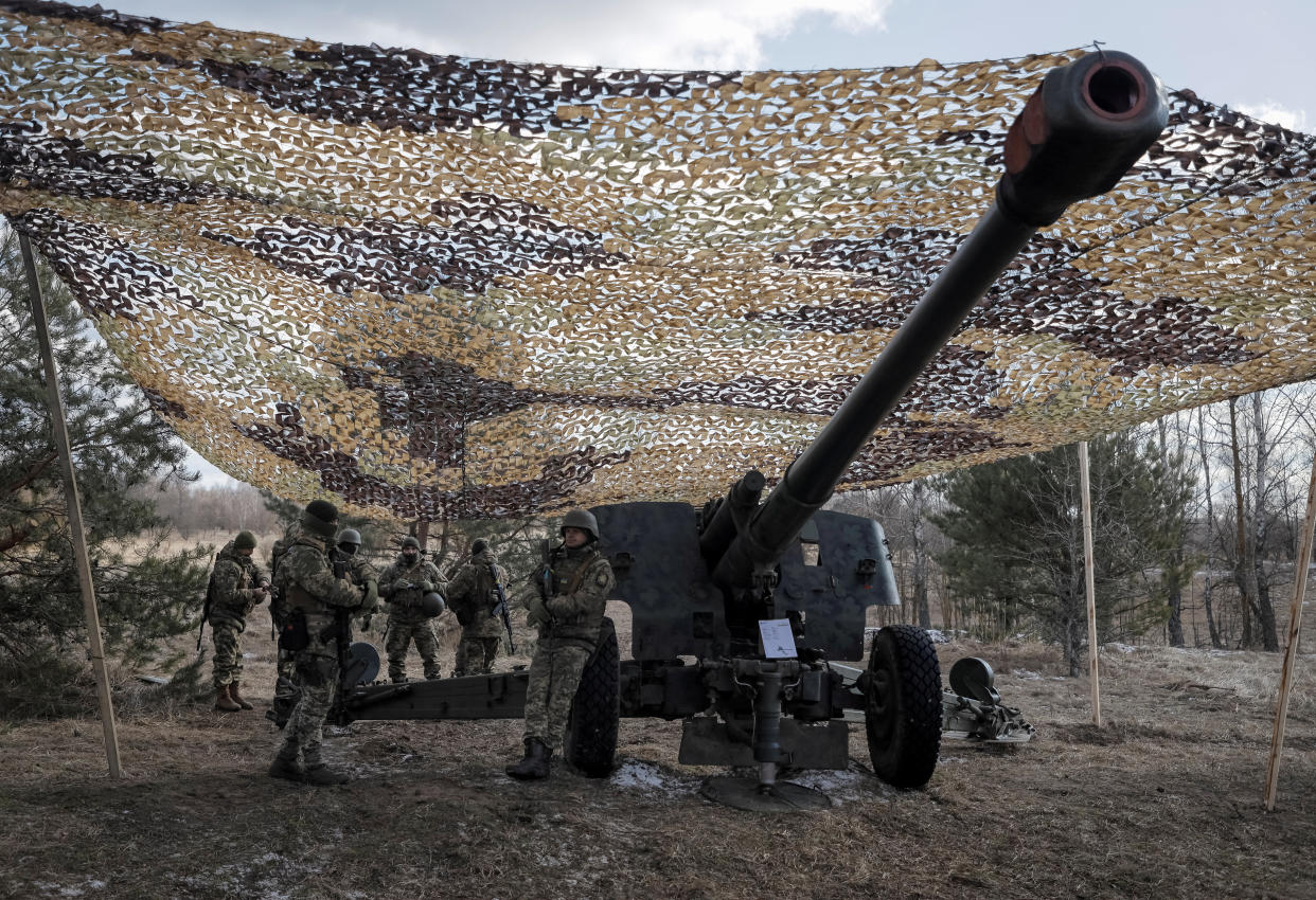 Ukrainian servicemen attend joint drills of Ukraine's armed forces, near Chernobyl, with a huge mounted artillery tank.