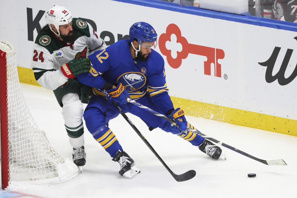 Buffalo Sabres left wing Jordan Greenway (12) is pressured by Minnesota Wild defenseman Zach Bogosian (24) during the third period of an NHL hockey game Friday, Nov. 10, 2023, in Buffalo N.Y. (AP Photo/Jeffrey T. Barnes)