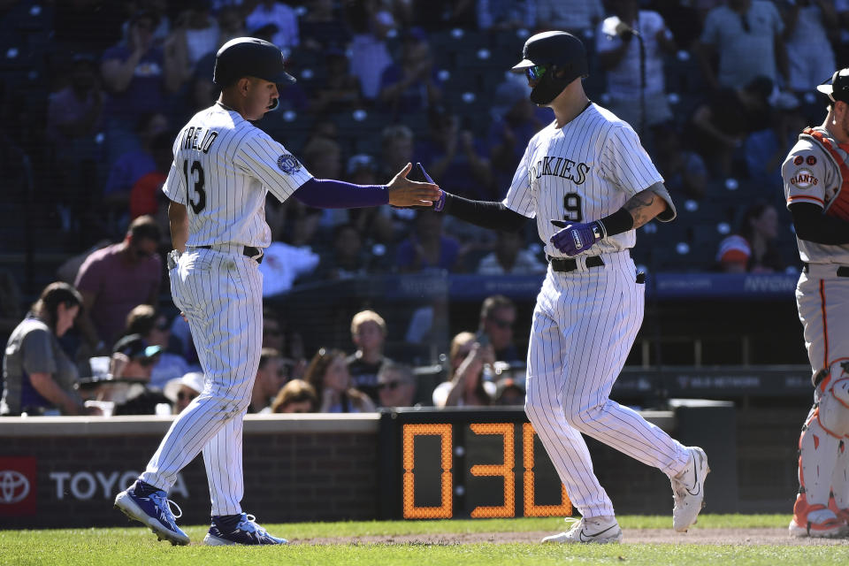 Colorado Rockies' Alan Trejo and Brenton Doyle celebrate a home run in the sixth inning of a baseball game against the San Francisco Giants, Sunday, Sept. 17, 2023, in Denver. (AP Photo/Geneva Heffernan)