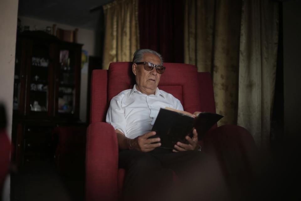 Minister Cirilo Ramirez, 77, reads in a chair