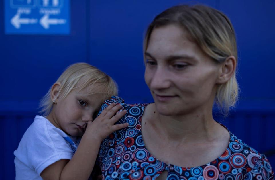 Tatiana Pidlesina y su hija Ulyana, de dos años, esperan en un centro de socorro en Zaporizhzhia para ser trasladadas a otra parte de Ucrania (Reuters)