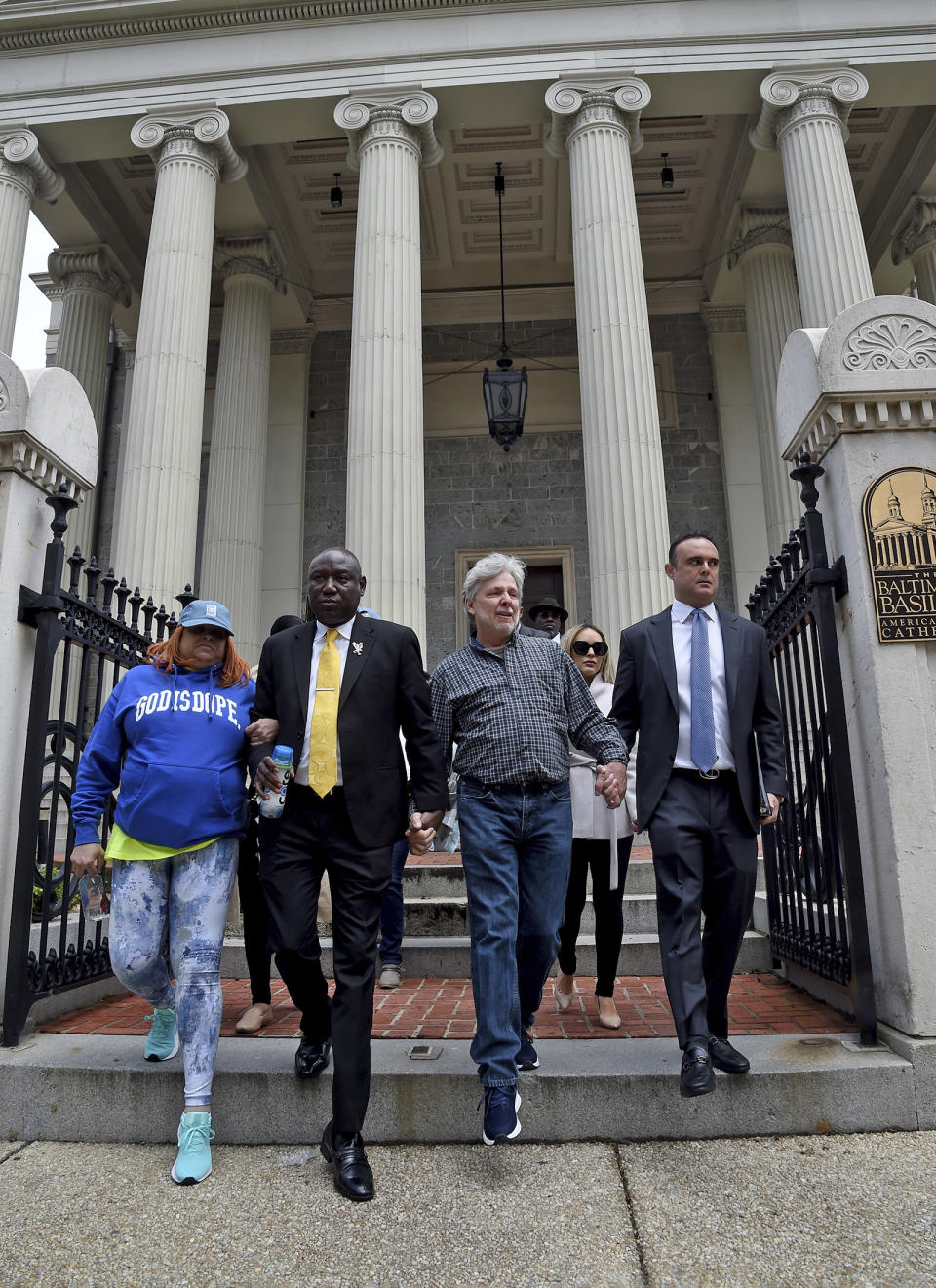 Victim Tanya Allen, from left, attorney Ben Crump, victim Marc Floto, and attorney Adam Stater descending the steps of the Baltimore Basilica for a news conference, Tuesday, May 9, 2023, in Baltimore. After Maryland lawmakers recently passed legislation eliminating the statute of limitations for child sex abuse lawsuits amid increased scrutiny of the Archdiocese of Baltimore, civil rights attorney Ben Crump announced a series of civil claims Tuesday he plans to bring on behalf of victims. (Barbara Haddock Taylor/The Baltimore Sun via AP)