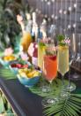 <p>No matter where you actually are, you can feel like you're in the tropics with this mimosa bar theme. Decorate with palm leaves, add "aloha" drink markers, and set up bowls with fresh cut pineapple, mango, and strawberry.</p><p>See more at <a href="https://liagriffith.com/tropical-bridal-shower-mimosa-bar/" rel="nofollow noopener" target="_blank" data-ylk="slk:Lia Griffith;elm:context_link;itc:0;sec:content-canvas" class="link ">Lia Griffith</a>.</p>