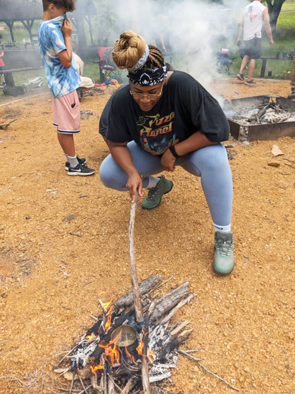Char Adams tends to a fire in Allex, Texas, at Texas Survival School in May. (Courtesy Char Adams)