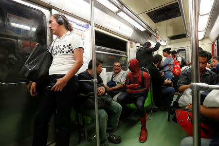 Moises Vazquez, 26, known as Spider-Moy, a computer science teaching assistant at the Faculty of Science of the National Autonomous University of Mexico (UNAM), who teaches dressed as a comic superhero Spider-Man, travels on a subway on his way to work in Mexico City, Mexico, May 27, 2016. REUTERS/Edgard Garrido
