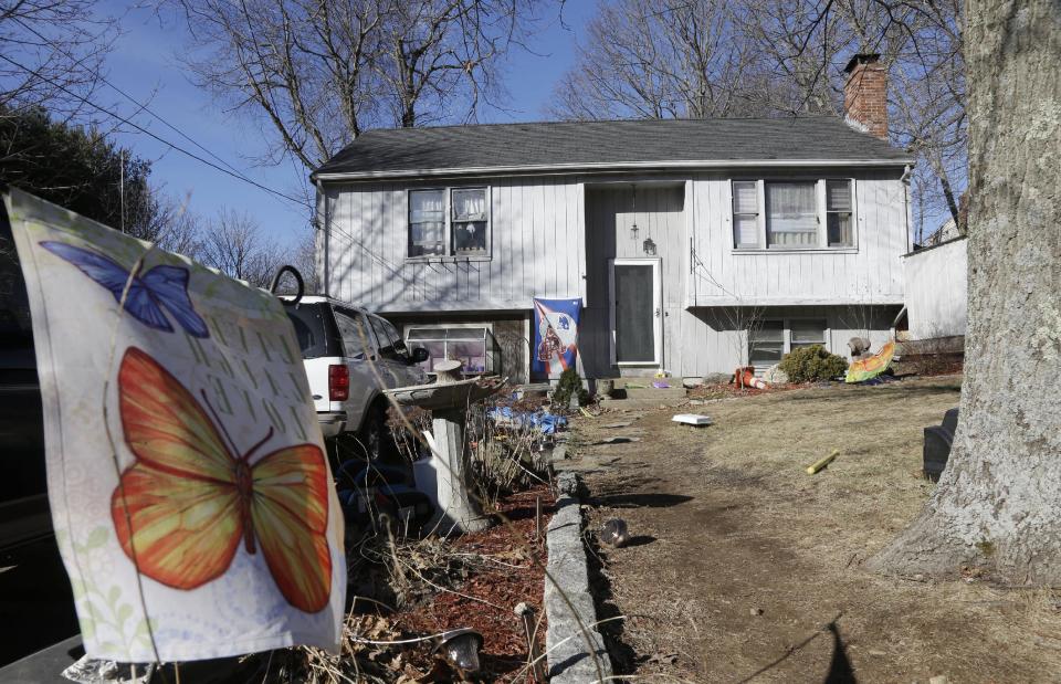 A banner with the likeness of butterflies is attached to a stake in front of a home Monday, Jan. 13, 2014, in Franklin, Mass., where authorities say a brother and sister under age 10 have died after apparently getting trapped inside a hope chest. Police responded to the Franklin home at about 8 p.m. Sunday after other family members found the children together inside the chest that could only be opened from the outside. (AP Photo/Steven Senne)