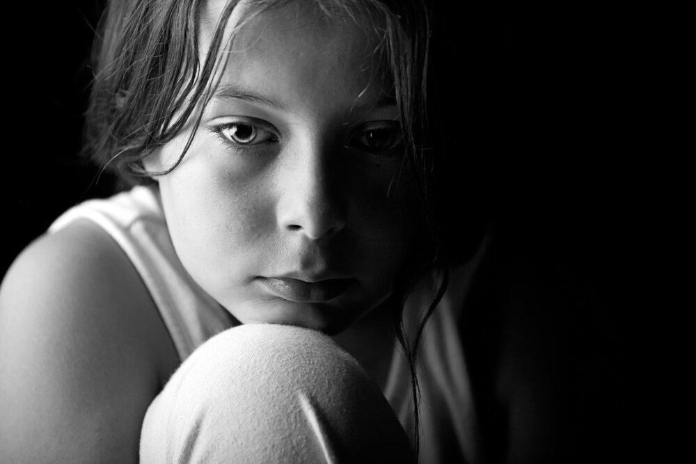 sad young girl sitting in the dark