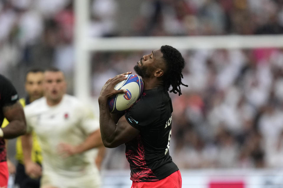 Fiji's Frank Lomani catches the ball during the Rugby World Cup quarterfinal match between England and Fiji at the Stade de Marseille in Marseille, France, Sunday, Oct. 15, 2023. (AP Photo/Pavel Golovkin)