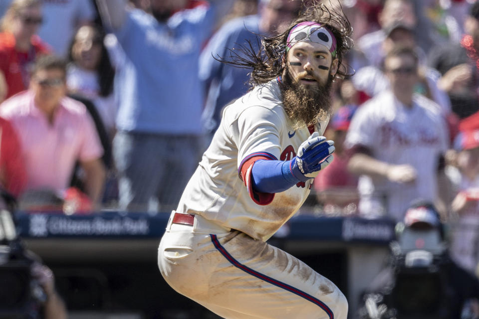 Philadelphia Phillies' Brandon Marsh is caught between third base and home on a rundown during the fourth inning of a baseball game against the Cincinnati Reds, Sunday, April 9, 2023, in Philadelphia. Marsh was tagged out on the play. (AP Photo/Laurence Kesterson)