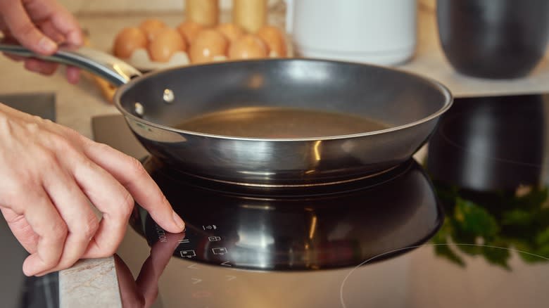 Person turning on induction hob