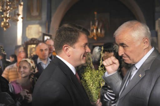 Presidential candidates, former local head of the KGB security service Leonid Tibilov (R) and human rights commissioner David Sanakoyev (L) talk as they visit a church in Tskhinvali, the capital of Georgian maverick region of South Ossetia on April 8, 2012