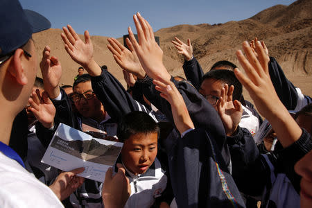 Students raise their hands to answer a question at the C-Space Project Mars simulation base in the Gobi Desert outside Jinchang, Gansu Province, China, April 17, 2019. REUTERS/Thomas Peter