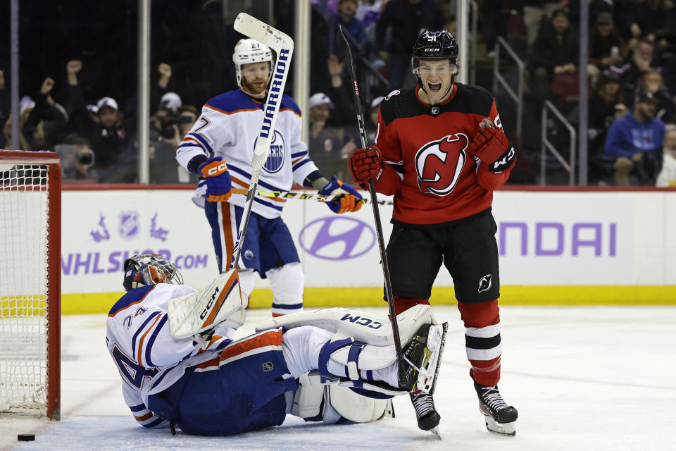 New Jersey Devils center Dawson Mercer (91) reacts after scoring a goal past Edmonton Oilers goaltender Stuart Skinner, bottom left, during the second period of an NHL hockey game Monday, Nov. 21, 2022, in Newark, N.J. (AP Photo/Adam Hunger)