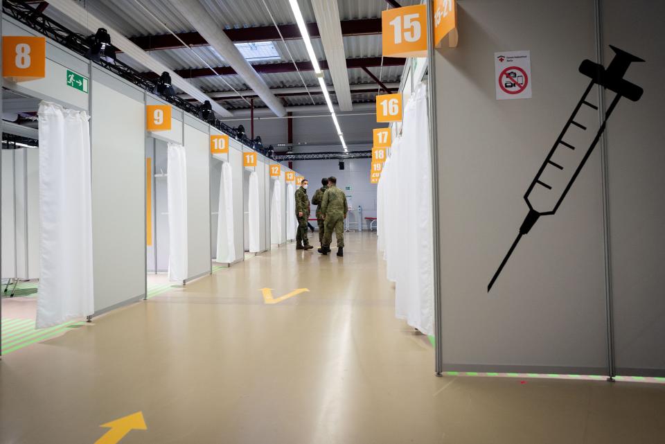 Soldiers of the German Armed Forces stand in a corridor at the newly opened vaccination centre in the area of the Terminal C in the former Berlin Tegel Airport, where inoculation with the OxfordAstraZeneca Covid-19 vaccine starts, in Berlin, on February 10, 2021. - Mainly nursing staff and medical personnel will be vaccinated against the coronavirus here. (Photo by Kay Nietfeld / POOL / AFP) (Photo by KAY NIETFELD/POOL/AFP via Getty Images)