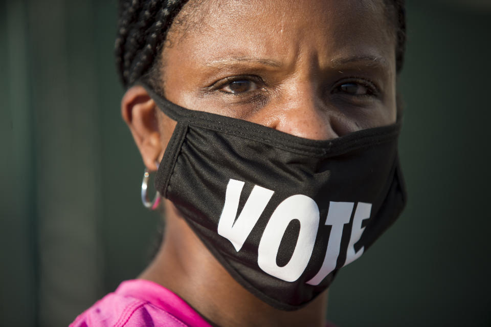 FILE - In this Oct. 26, 2020, file photo, Caprice Clipps wears a "vote" mask as she waits outside the Smoothie King Center in New Orleans for one of the last days of early voting. Several years since its founding, BLM has evolved well beyond the initial aspirations of its early supporters. Now, its influence faces a test, as voters in the Tuesday, Nov. 3 general election choose or reject candidates who endorsed or denounced the BLM movement amid a national reckoning on race. (Chris Granger/The Advocate via AP, File)