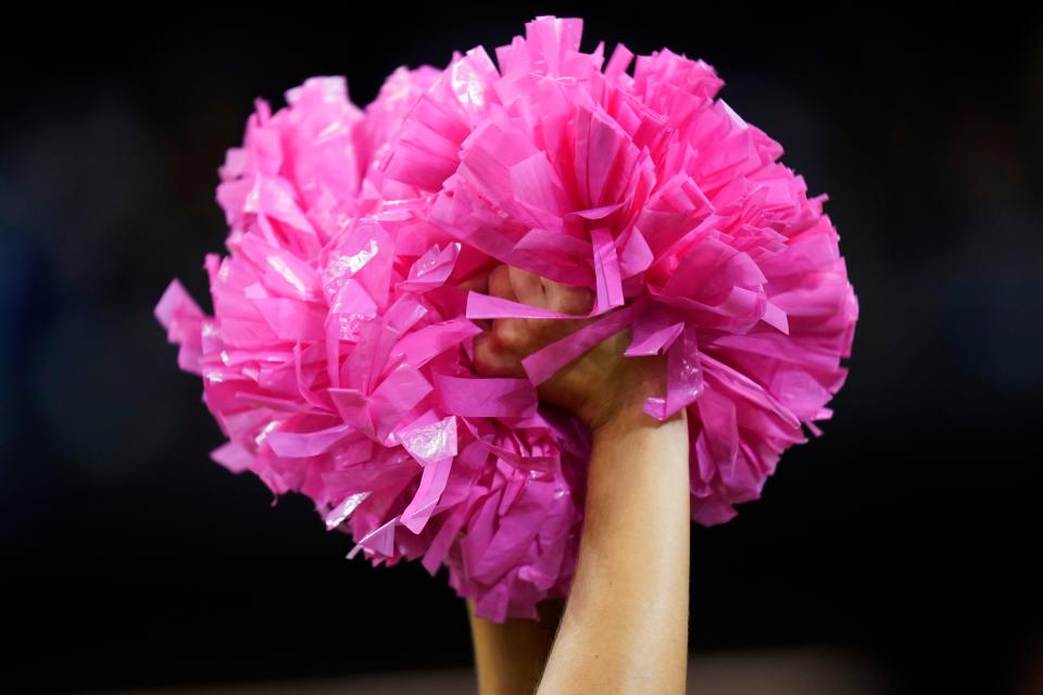 A New Orleans Saints cheerleader holding pompoms for Breast Cancer Awareness Month performs before an NFL football game between the New Orleans Saints and the New York Giants in New Orleans, Sunday, Oct. 3, 2021. (AP Photo/Brett Duke)