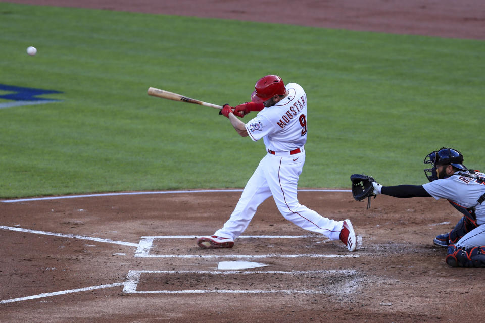 Cincinnati Reds' Mike Moustakas (9) hits an RBI-single in the first inning of a baseball game against the Detroit Tigers at Great American Ballpark in Cincinnati, Friday, July 24, 2020. (AP Photo/Aaron Doster)