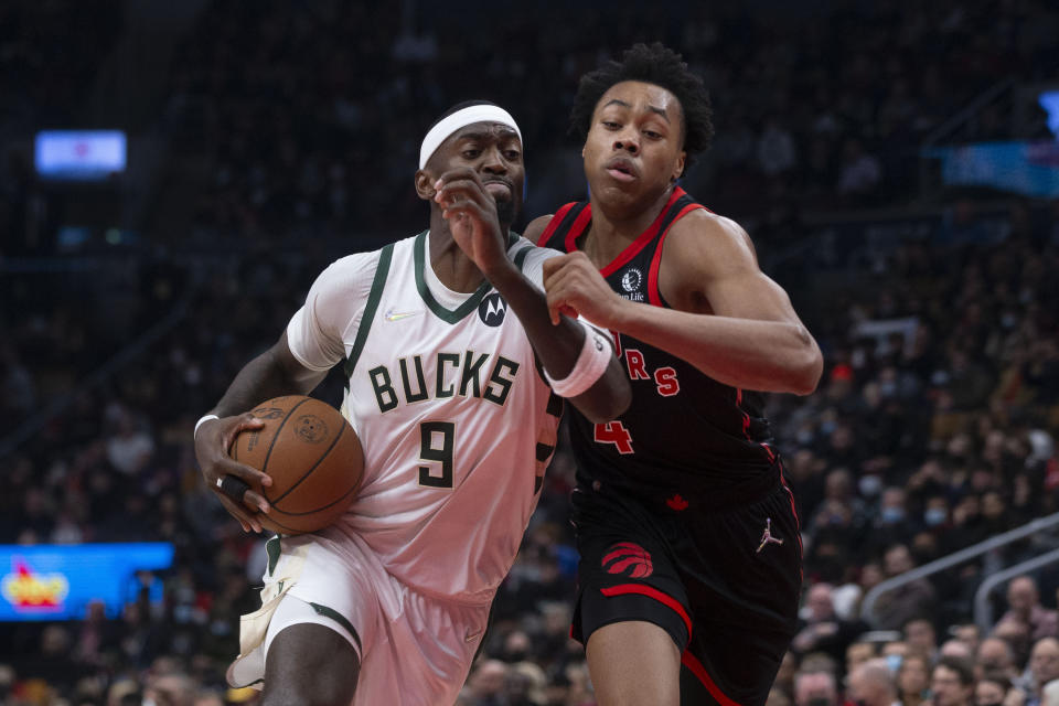 Milwaukee Bucks' Bobby Portis, left, drives past Toronto Raptors' Scottie Barnes during the first half of an NBA basketball game Thursday, Dec. 2, 2021, in Toronto. (Chris Young/The Canadian Press via AP)