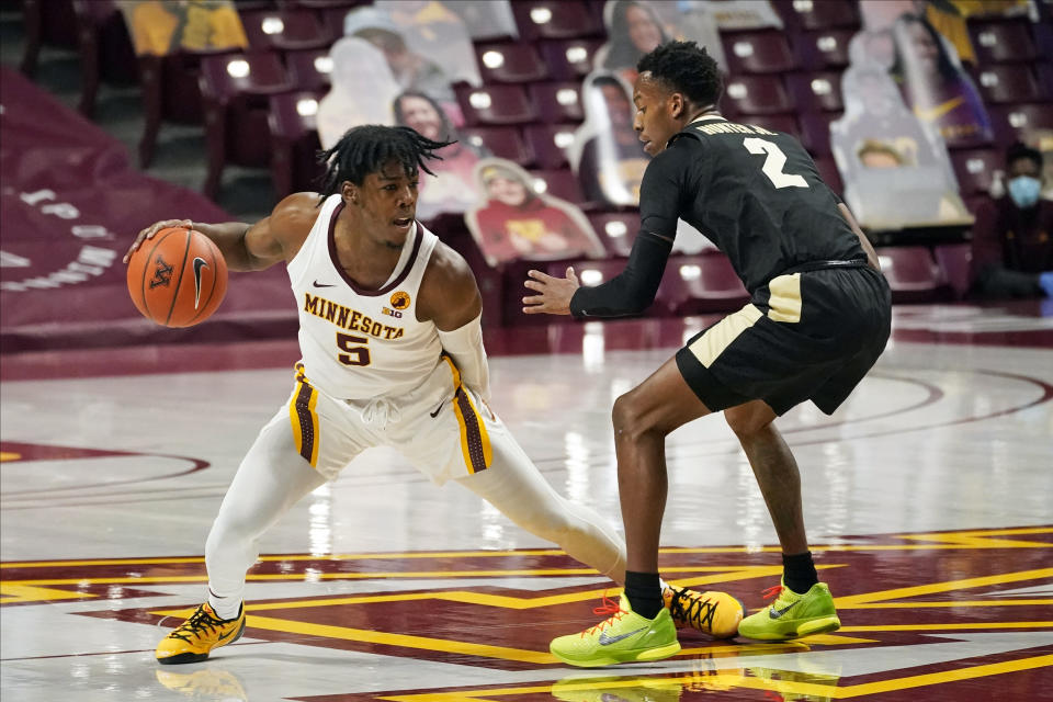 Minnesota's Marcus Carr (5) drives as Purdue's Eric Hunter Jr. (2) defends in the first half of an NCAA college basketball game, Thursday, Feb. 11, 2021, in Minneapolis. (AP Photo/Jim Mone)