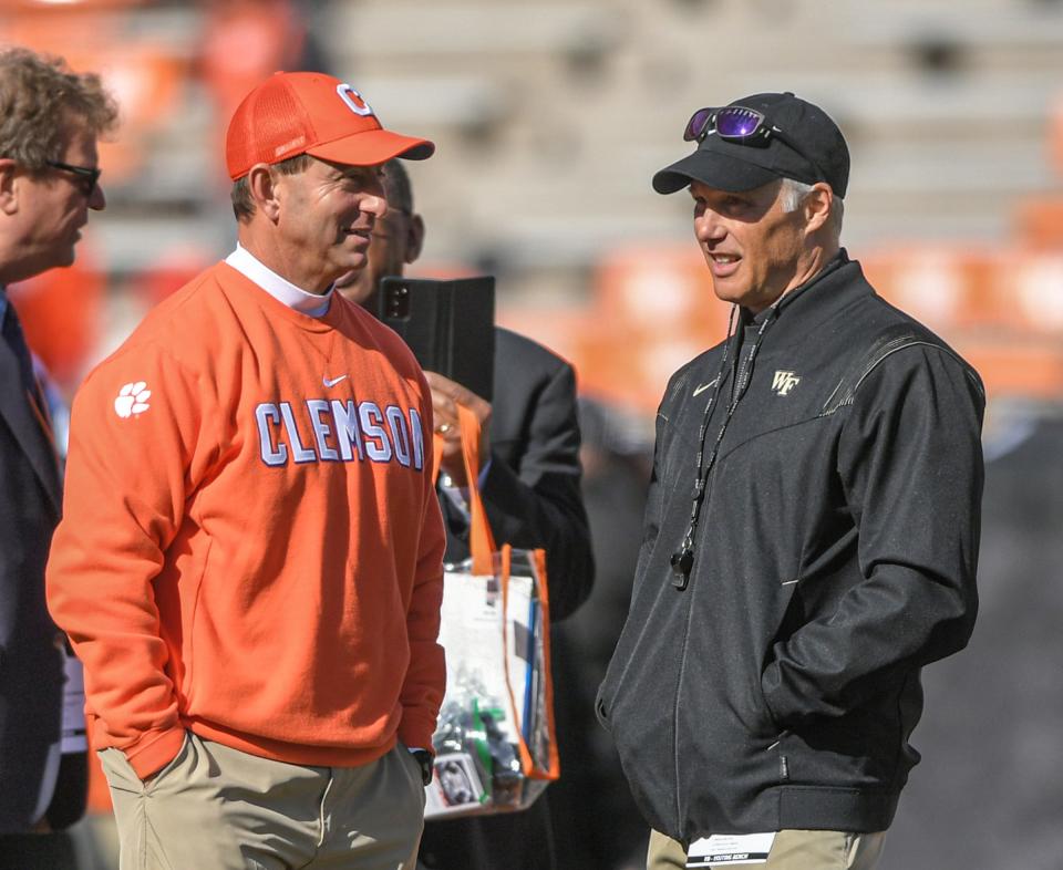 Clemson head coach Dabo Swinney, left, talks with Wake Forest Head Coach Dave Clawson as players warm up before the game with Wake Forest at Memorial Stadium in Clemson, South Carolina Saturday, November 20, 2021.