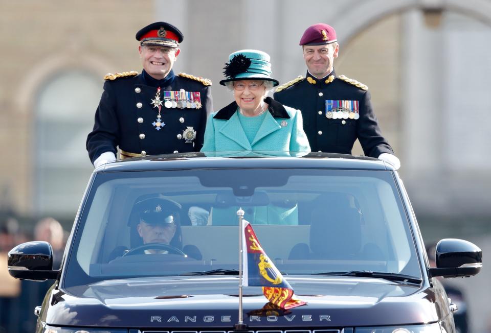 <p>Isn’t this just the most adorable photo ever!? Queen Elizabeth toned things down for this occasion, opting for a more reserved hue of green with black detail. [Photo: Getty] </p>