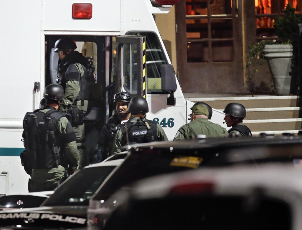 Heavily armed police wear flack jackets and helmets as they prepare to search the Garden State Plaza mall in response to reports that a gunman had fired shots in the mall, in Paramus, New Jersey November 5, 2013. A person with a gun opened fire on Monday evening in the massive New Jersey shopping mall shortly before closing time, leading police to evacuate the mall and search for the shooter, but no injuries were reported, officials said. (REUTERS/Ray Stubblebine)